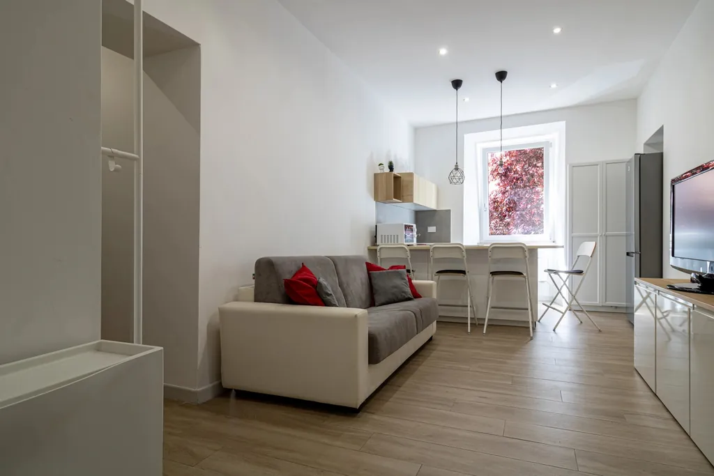 Il salone con il divano letto e la cucina a vista in fondo